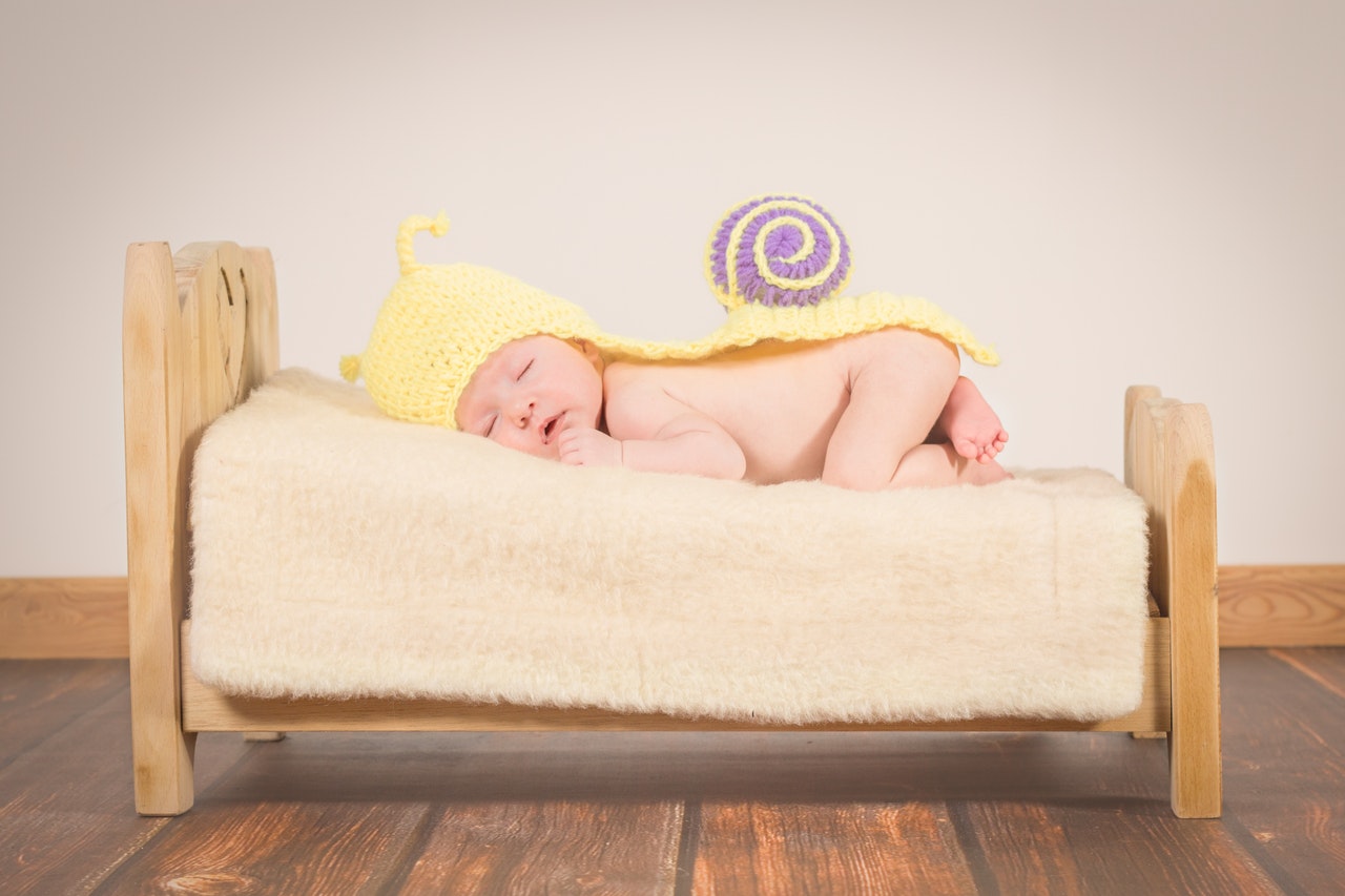 baby sleeping in wooden flooring room